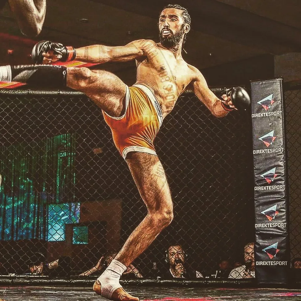 Coach Amar Johal throwing a high kick during an MMA fight