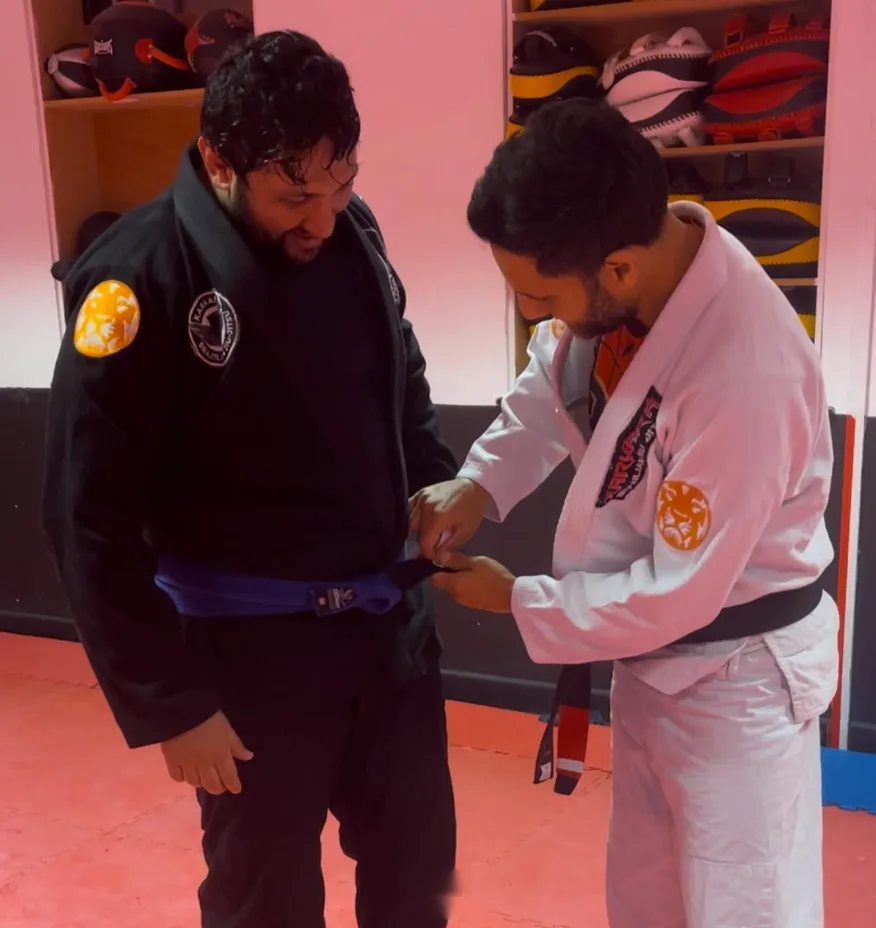 A student receiving his blue belt promotion
