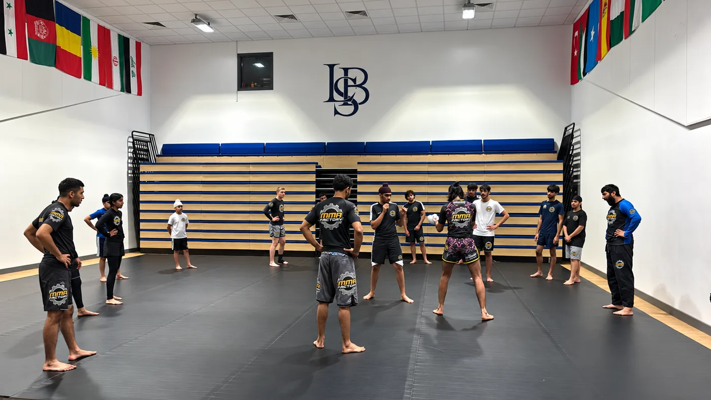 MMA Factory class gathered on the mats in the Lordswood Boys' School sports hall
