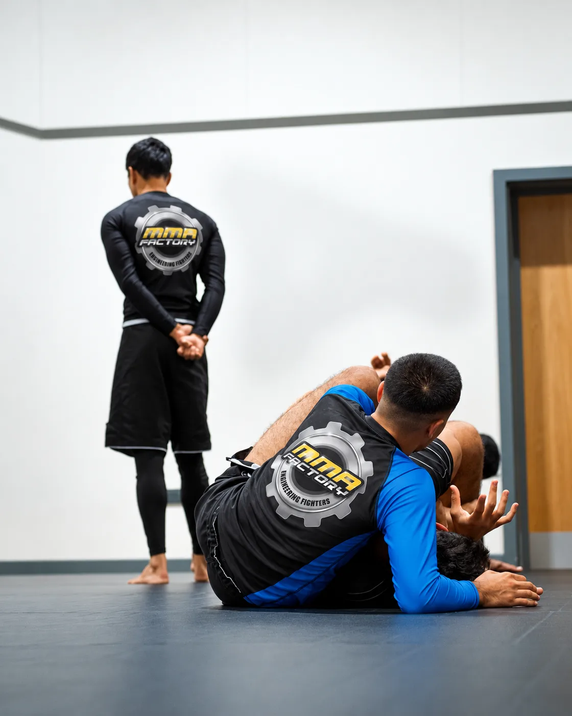 MMA Factory members in branded rashguards during grappling practice